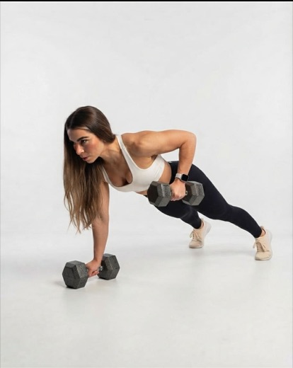 A dancer doing a plank row with dumbbells.
