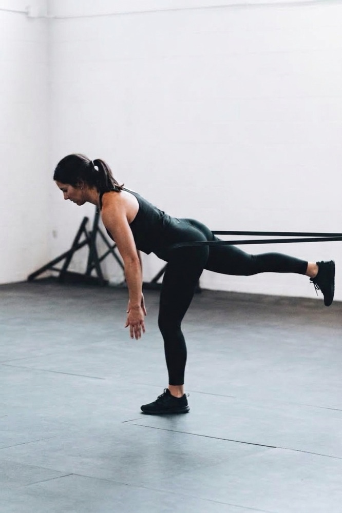 A dancer balancing in an arabesque during a coaching session.